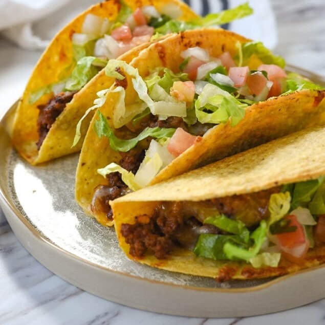 three baked tacos on a plate
