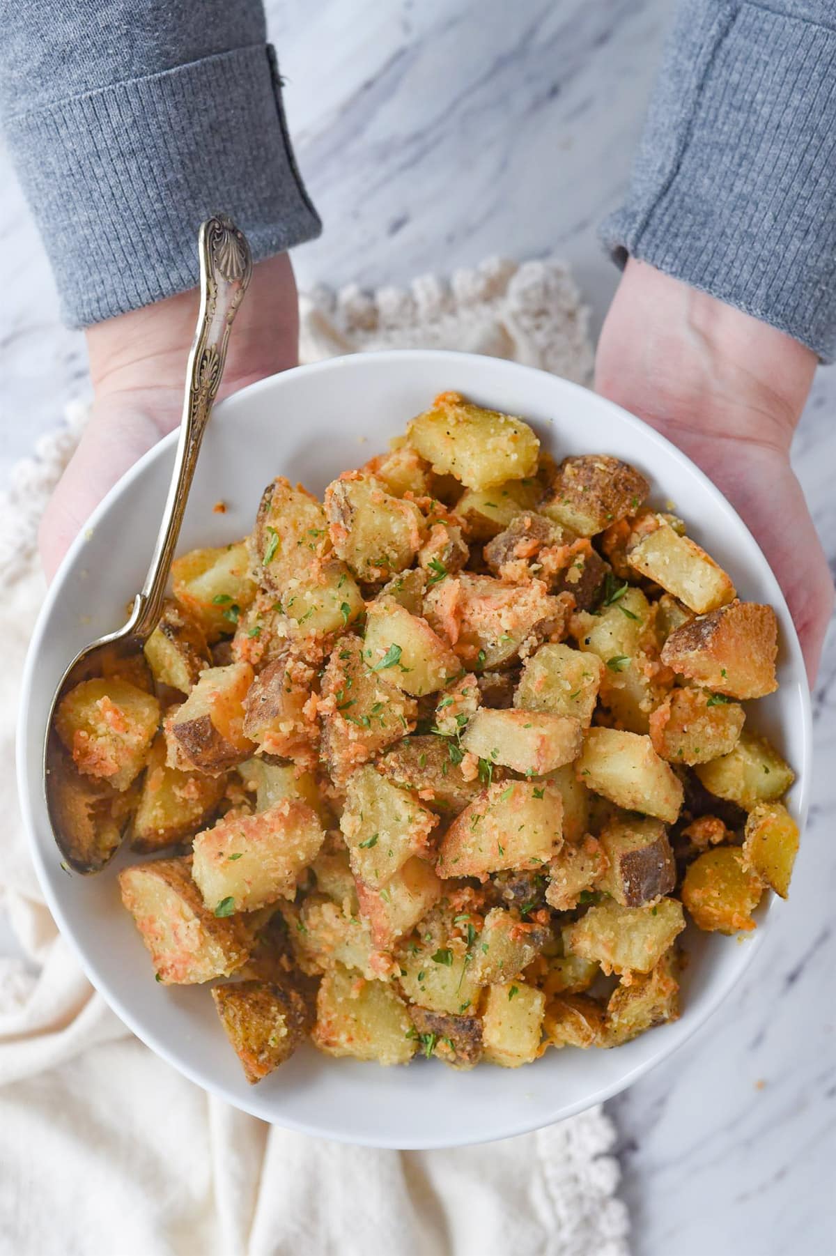 parmesan roasted potatoes hands holding bowl of parmesan roasted potatoes