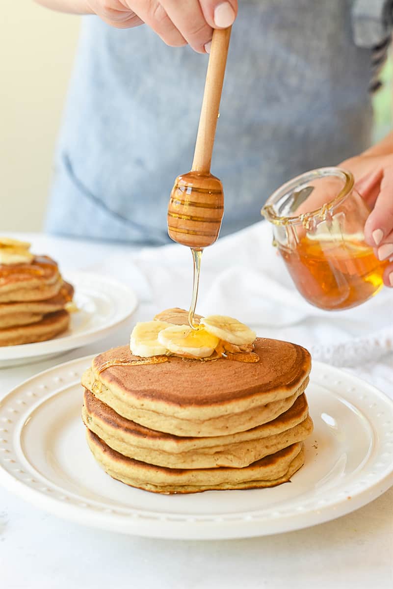 pouring honey on pancakes